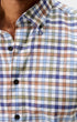 Close-up of a men's button-down shirt with a multicolor plaid pattern in blue, purple, green, and brown on a white base, worn by a model.