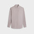 A long-sleeve button-up shirt in a fine micro-patterned fabric, featuring a light pink and white design, displayed on a neutral light gray background.