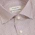 Close-up of a Bugatchi men's dress shirt with a fine repeating geometric pattern in dusty pink, beige, and gray, featuring a white collar label and white buttons.