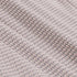 Close-up of a textured fabric with a repeating hexagonal mesh pattern in a light gray and dusty pink colorway.