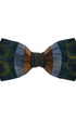 A men's self-tie bow tie featuring a multi-colored patchwork design with peacock-feather-inspired circular motifs in blue, green, and gold, accented by vertical stripes of brown, orange, and gray, finished with a dark gray elastic band.